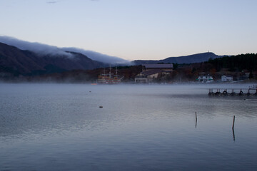 Fototapeta na wymiar A lake in the Mt Fuji Region called, The Five Lakes, can be seen in the early morning in Autumn, It is cold and mist is rising from the water surface and frost is on the ground. Japan