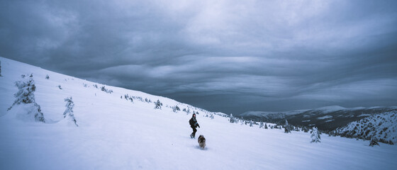Woman climbing on the mountain, woman with a backpack walking on snow, Krkonose, Czech republic