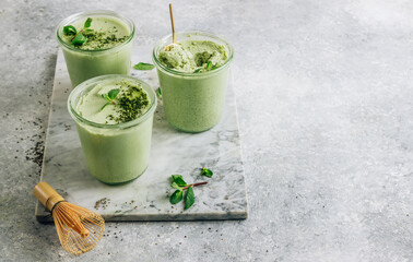 Raw vegan dessert. Matcha green tea chia seed pudding with fresh mint and coconut milk on a gray...