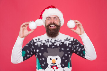 happy bearded man play with new year decorative snowball wearing funny knitted sweater and santa claus hat for celebrating new year holiday, happy new year. festive decor