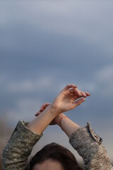 Female hands on the background of clouds
