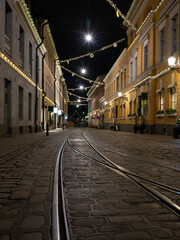 Fototapeta na wymiar A tranquil scene of an empty European alley with tramway tracks on the stone pavement.