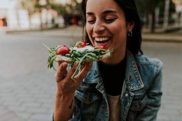 beautiful woman eating street food in barcelona
