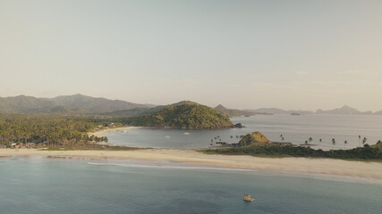 Green mountains island at ocean bay aerial. Tropic nobody nature seascape. Serene sea water at sand coast. Summer paradise at Philippines, El Nido Islet. Cinematic rise up drone shot