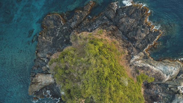 Top down closeup at green island at sea bay aerial. Nobody nature landscape of El Nido Islet, Philippines, Asia, Visayas Archipelago. Tropical exotic trees at rock isle top. Greenery plants on cliff © Goinyk