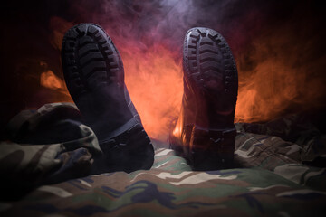 War concept. Old military shoe in a dark toned foggy background. Creative concept of conflict...