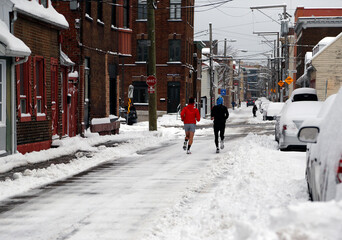 deux coureurs dans une rue enneigée dans la ville de Québec en hiver