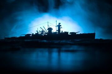 Silhouettes of a crowd standing at blurred military war ship on foggy background. Selective focus. Passengers try to escape. Protest of people