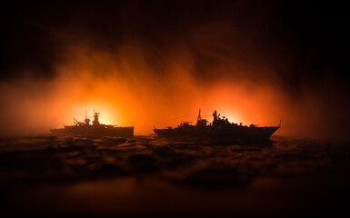 Silhouettes of a crowd standing at blurred military war ship on foggy background. Selective focus....