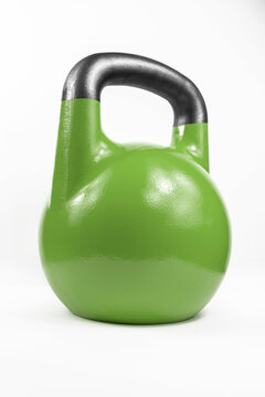 Classic traditional heavy cast iron green kettle bell shot in a white studio at an angle.