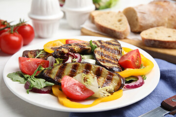 Delicious salad with roasted eggplant served on table, closeup