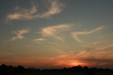 Fototapeta premium The orange light of sunrise, clouds , blue sky and silhouette in the morning