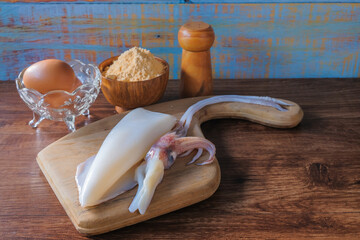 Squid and egg on wooden background.