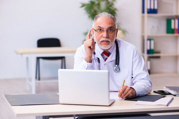 Old male doctor working in the clinic