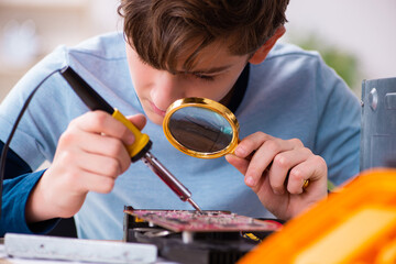Boy reparing computers at workshop