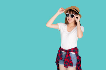 Beautiful portrait young asian woman wear hat and holding sunglasses smiling confident enjoy journey summer trip in vacation isolated on blue background, tourist asia girl cheerful with travel.