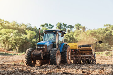 Farmer drives a tractor on a sunny summer day