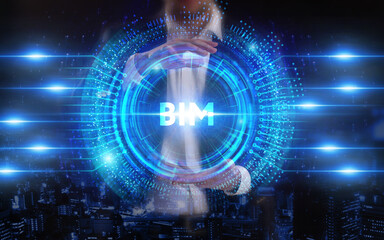 Fototapeta premium Business, Technology, Internet and network concept. Young businessman working on a virtual screen of the future and sees the inscription: BIM