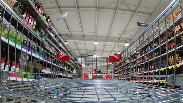 POV (point of view) hyper lapse of shopping cart rushing inside unrecognizable supermarket. No people. Copy space