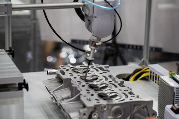 Fototapeta na wymiar Industrial robot arm demonstrate assembly engine part