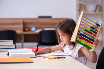 Small girl preparing for exams at home