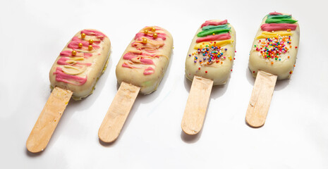 Cakesicles coated with white Chocolate and multicoloured toppings