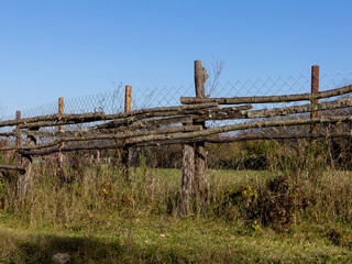 Fototapeta na wymiar Old wooden fence on a ranch on a Sunny autumn day.