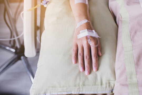 Close up of hands patient women receiving saline solution during sleeping on sick bed at the hospital