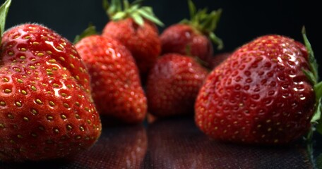 Delicious juicy strawberry. Macro shot of strawberries on black background. Strawberries close-up. 