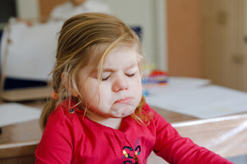 Fototapeta premium Cute upset unhappy toddler girl crying. Angry emotional child shouting. Portrait of kid with tears.