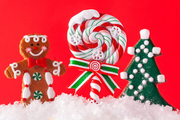 Christmas Lollipop, Christmas tree, ginger man in the snow on a red background. Happy New year. Christmas background.