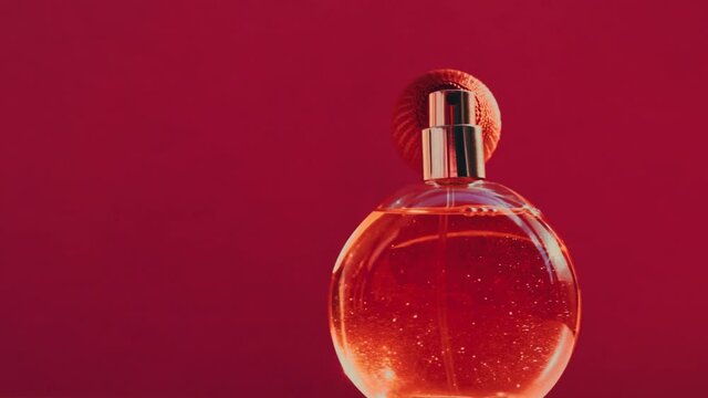 Vintage perfume bottle and shining light flares on red background, glamorous fragrance scent as luxury perfumery product for cosmetic and beauty brand, stock footage