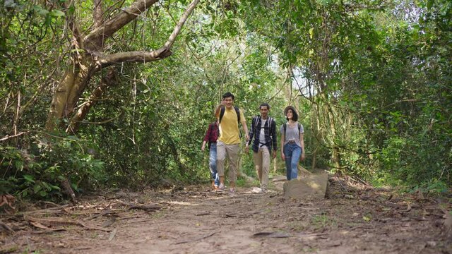 Group of multi ethnicity friend travel through a forest in the summer.	