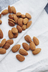 Almond kernels on white fabric. A handful of nuts on the tablecloth. Food for vegans, ingredients for making almond milk