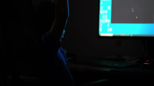 Asian boy late at night launches the game on the computer, typing something interesting surfing Internet, moonlight shines from window. close up view. Slow motion nvideo. stock footage