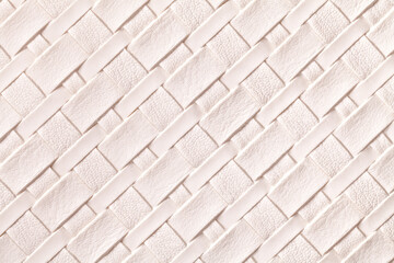 Texture of light pink leather background with wicker pattern, macro.