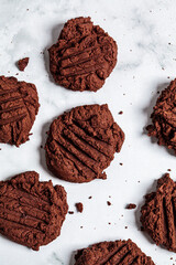 Homemade vegan chocolate cookies on white marble background, top view. Vegan baking concept.