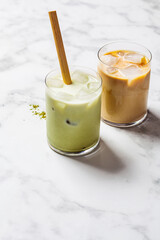 Cold summer drinks concept. Ice latte matcha and ice latte coffee in glasses, white background.