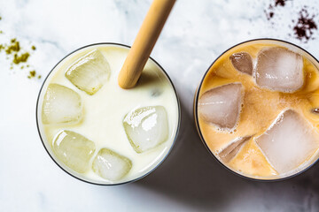 Cold summer drinks concept. Ice latte matcha and ice latte coffee in glasses, top view, white background.