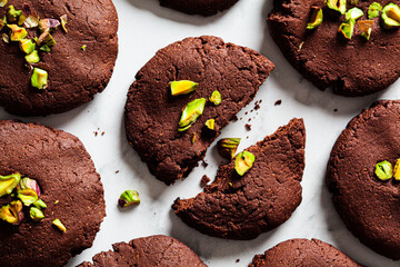 Homemade vegan chocolate cookies with pistachios on  white marble background, top view. Vegan...