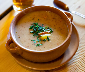 Original national dish of Polish cuisine - traditional soup zur with eggs garnished with fresh greens