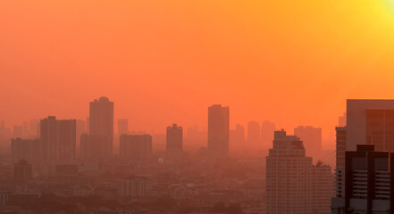 Fototapeta na wymiar Air pollution in Bangkok, Thailand. Smog and fine dust of pm2.5 covered city in the morning with orange sunrise sky. Cityscape with polluted air. Dirty environment. Urban toxic dust. Unhealthy air.