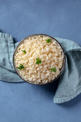 Rice with parsley, shot from above on a blue background with a place for text