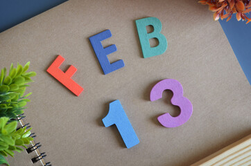 February 13, Cover design in natural concept with a brown notebook and colorful wooden alphabet.