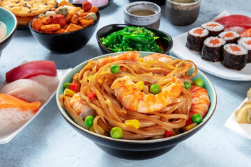 Japanese food. Stir fried noodles with shrimps, nigiri, maki and green tea