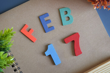 February 17, Cover design in natural concept with a brown notebook and colorful wooden alphabet.