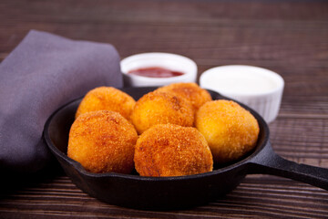 Potato croquettes balls on the iron pan and dips sauces