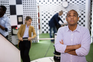 Obraz premium Portrait of bewildered man spending time with his colleagues in quest room