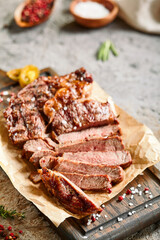 Classic ribeye steak served in waxed paper on wooden cutting board