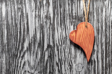 Wooden heart on a black wooden background.